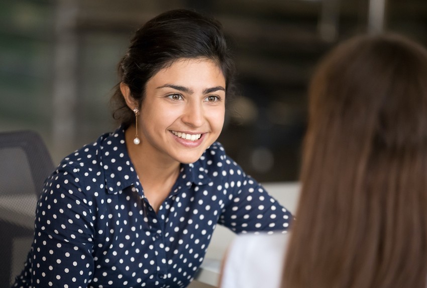 Person leans forward to listen to someone they are talking to