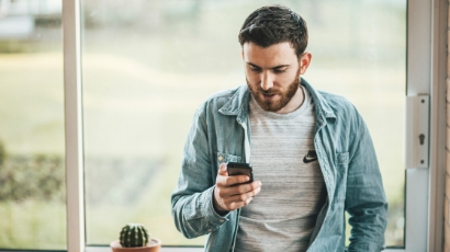 Man with a beard looking at his mobile phone