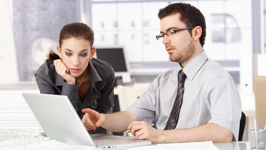 Two employees looking at a computer screen