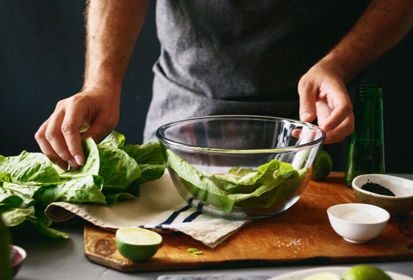 Food: man preparing leafy green vegetables.
